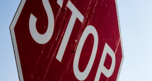 Abstract close up of an old dirty stop sign with a blue sky