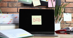 Sticky,Note,With,Word,Sos,,Laptop,And,Stationery,On,Wooden